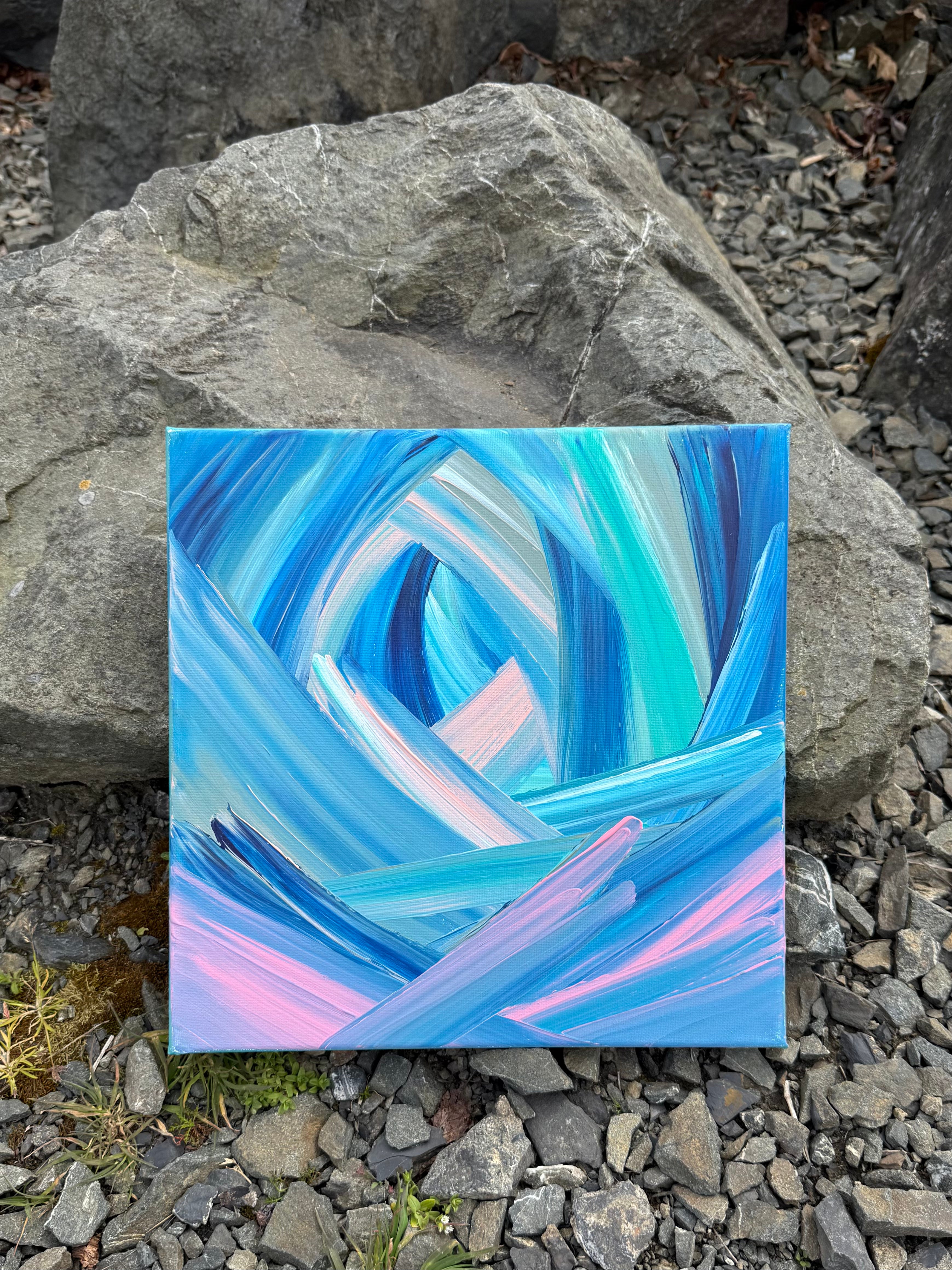 Abstract painting with blue and pink swirls on a rocky surface