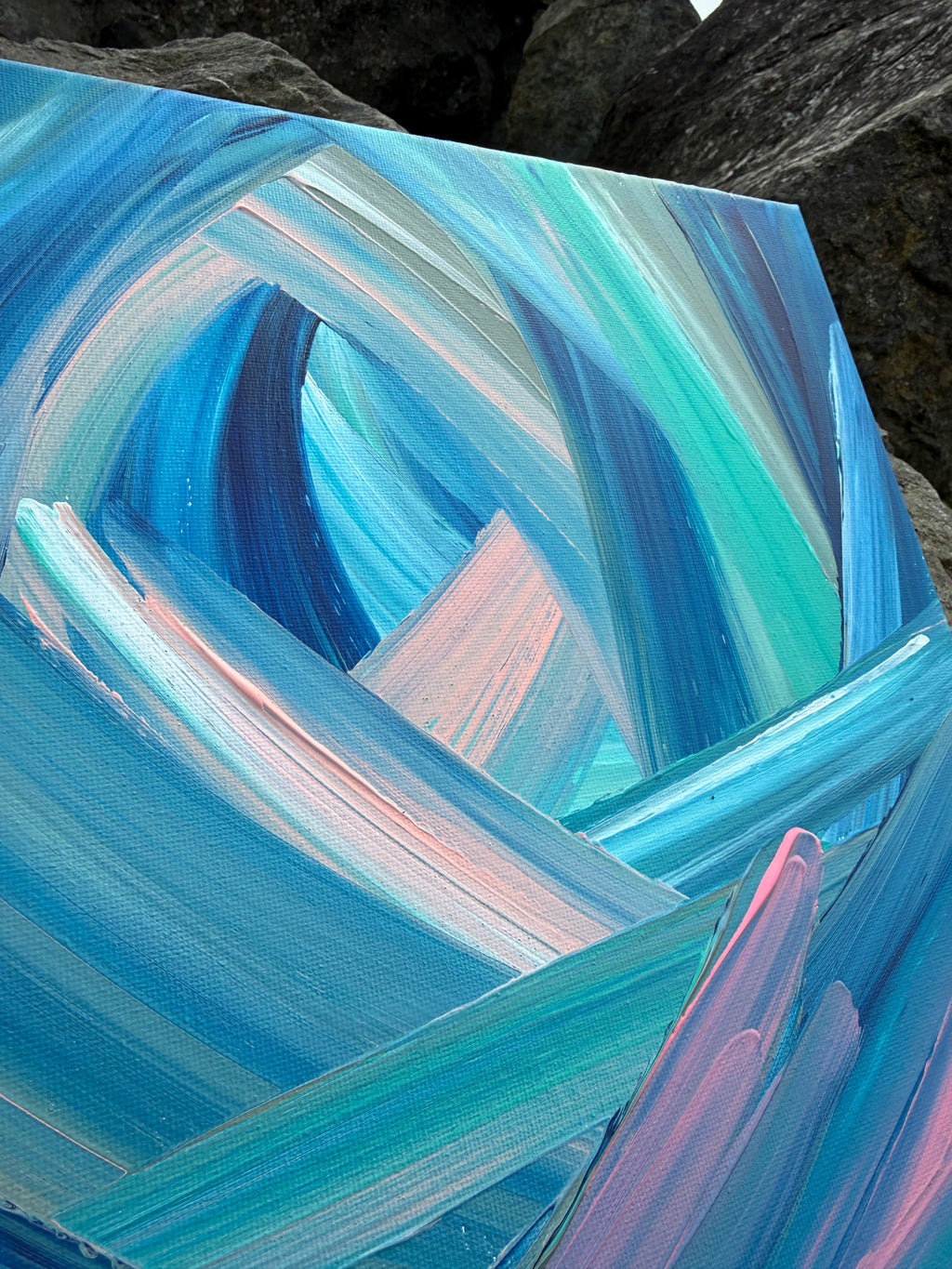 Abstract painting with swirling blue and pink brushstrokes on a dark background