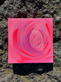 Pink spiral painting on a textured stone surface