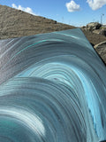 Close-up of a textured blue surface with a natural landscape in the background